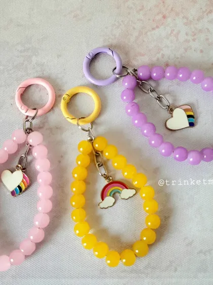 This image shows the collection of pastel beaded charms with rainbow hearts. You can choose from pink, yellow, or purple to match your mood.