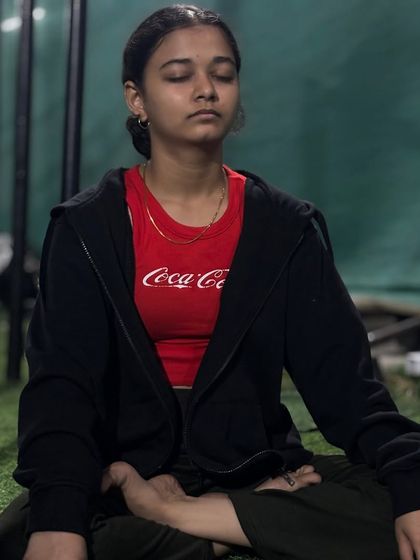 A female athlete finds her focus during a cool-down meditation, an essential part of recovery and mental preparation.