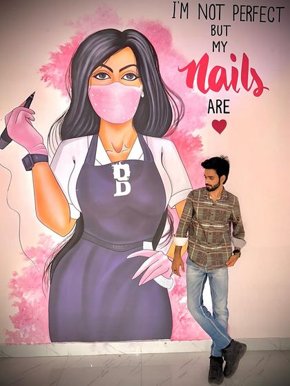 Me standing in front of the mural at my studio. The quote "I'm not perfect but my nails are" is my motto.