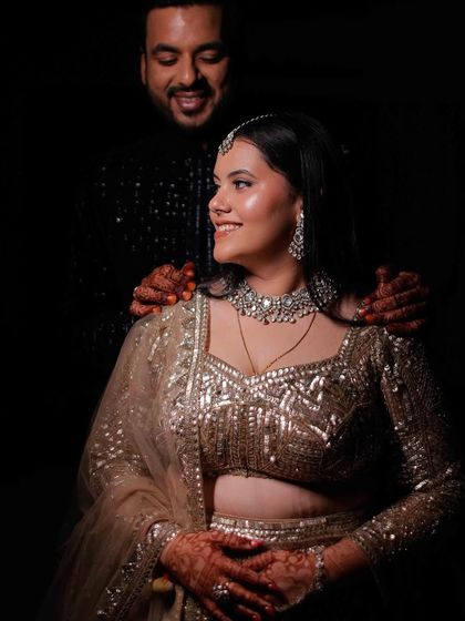 A beautiful, candid moment between the couple. The bride's radiant makeup looks stunning even in a softly lit, intimate setting, highlighting her smile and the joy of the moment.