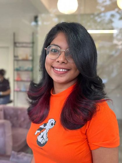 A smiling client showing off her new playful red tips.