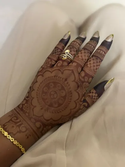 The back of her hand, featuring a classic mandala design.