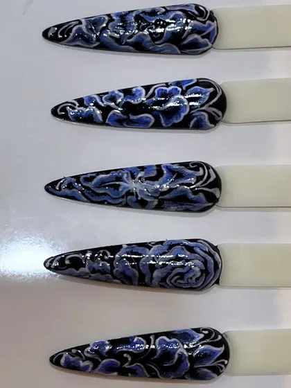 A close-up of the hand-painted vintage-style floral nail art.