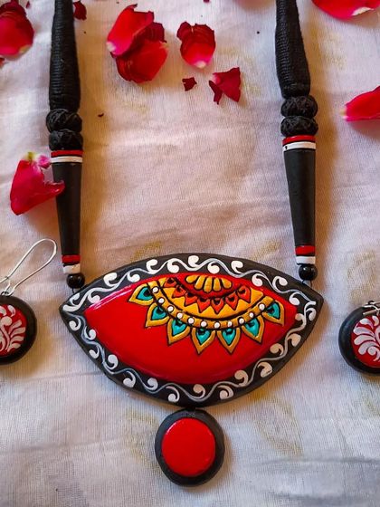 A third variation of the red and black eye-shaped pendant, with a delicate white border.