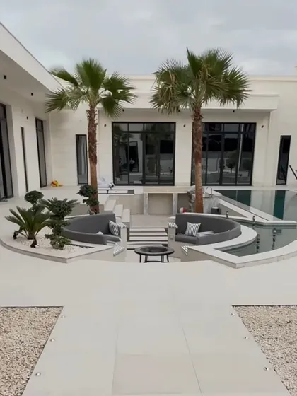 Another perspective of the sunken lounge area, framed by two beautiful palm trees. This design creates an intimate and exclusive space for relaxation by the pool.