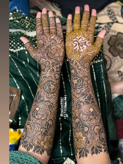 An engagement bride's mehendi, featuring her partner's name 'Kashif' beautifully written in Arabic calligraphy on the palm.
