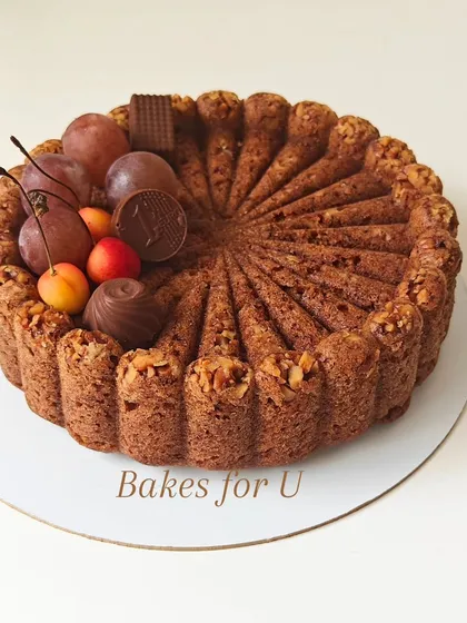 My whole wheat Bundt cake decorated with fresh cherries, grapes, and assorted chocolates. The intricate shape of the cake itself is a beautiful centerpiece.