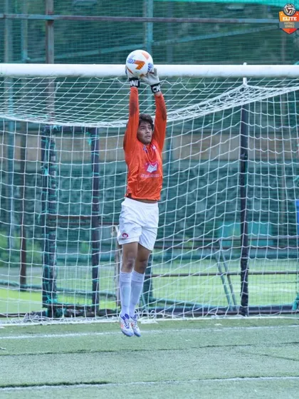 A goalkeeper confidently claims the ball, showcasing the reliability of our defense.