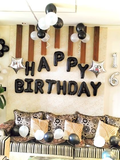A simple and classic "Happy Birthday" wall decoration for a 16th birthday. The black foil balloons are complemented by black and white latex balloons for a clean, monochromatic look.