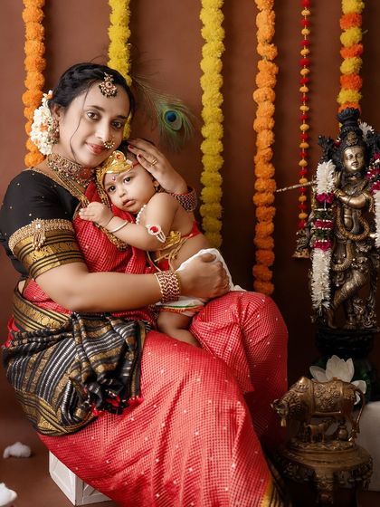 A tender portrait of a mother holding her baby close, with the child resting his head on her shoulder.