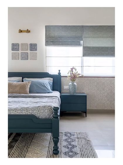 A detail of the master bedroom, showing how patterns are layered within a single color palette. The blue bed, patterned rug, and tiled artwork create a cohesive and calming look.
