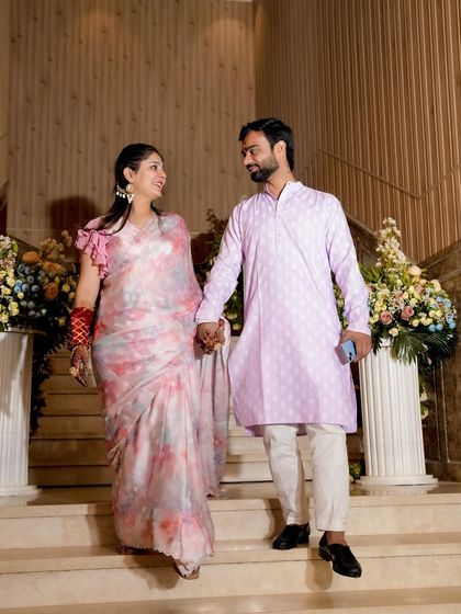 A lovely, candid shot of a couple descending a staircase during their Haldi ceremony, capturing the simple elegance of the moment.