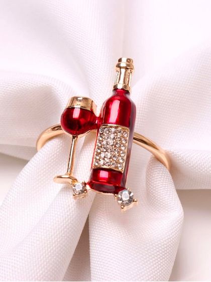 Here is the wine-themed napkin ring holding a crisp white napkin. The rich red enamel of the bottle and the sparkle of the tiny crystals create a festive and celebratory feel.
