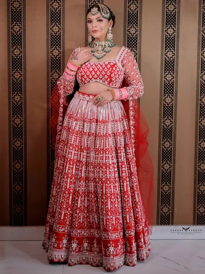 A full-length view showing the complete bridal look, emphasizing the flow and design of the lehenga.