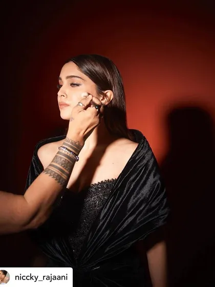 A candid moment of me doing a final touch-up on Sharvari. This shows the hands-on nature of my work as a celebrity makeup artist.