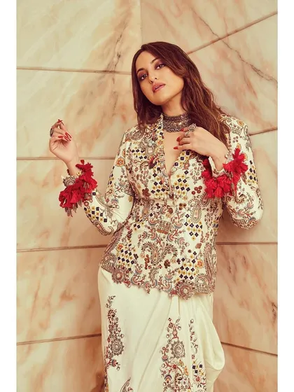 A closer look at the Anamika Khanna fusion set, highlighting the intricate embroidery and the playful red tassels on the sleeves.