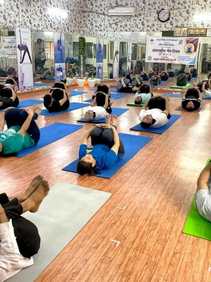 Students practicing Pavanmuktasana (Wind-Relieving Pose) during a group class. This pose is excellent for digestive health and releasing lower back tension.