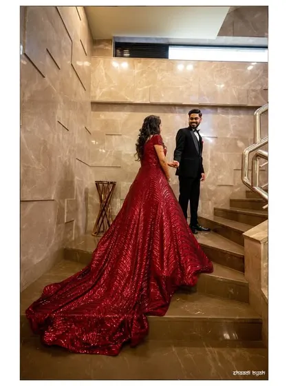 A creative shot of the couple on a staircase, again highlighting the dramatic flow and length of the bride's gown.