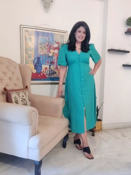 The full look of the green dress. The button-front detail and puff sleeves give it a sophisticated yet modern feel, perfect for an evening of culture and fine dining.