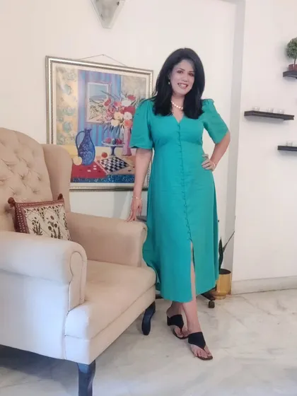 The full look of the green dress. The button-front detail and puff sleeves give it a sophisticated yet modern feel, perfect for an evening of culture and fine dining.
