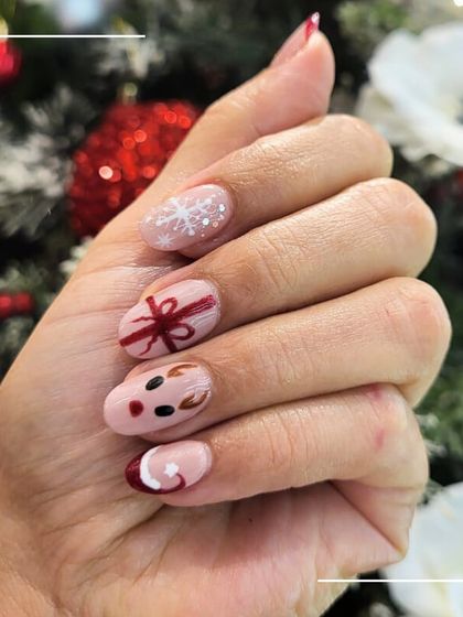 A close-up of our festive nail art, highlighting the detailed work in each design, from the reindeer to the tiny gift bow.