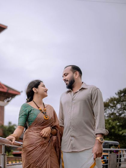 A quiet, conversational moment on a bridge or walkway, with the city in the background.