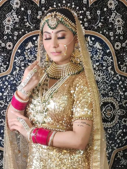 A beautiful bridal portrait showcasing a heavy Kundan and pearl set against a golden sequin lehenga.