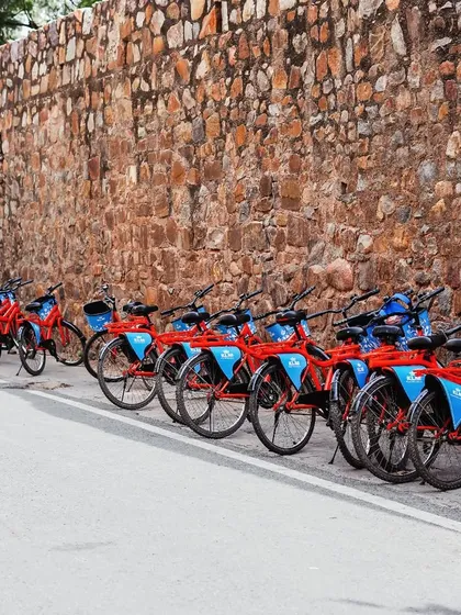 Our fleet of signature red and blue cycles, all lined up and ready for an adventure. Just park your worries, hop on, and let's explore together.