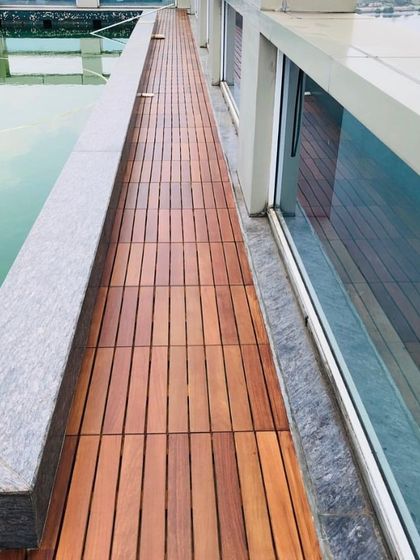 Even narrow walkways benefit from IPE decking. Here, it creates a safe and attractive path alongside the pool's edge, connecting different areas of the terrace.