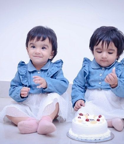 A sweet moment during the twins' cake smash session. Before the real mess begins, we capture these cute portraits with the birthday cake.