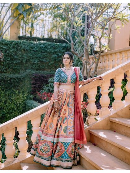 A classic bridal portrait on a staircase, showcasing her elegant poise and the beautiful details of her outfit.