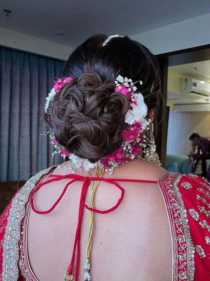 A close-up of the textured floral bun, showcasing the detail in both the hairstyle and the fresh flower arrangement.