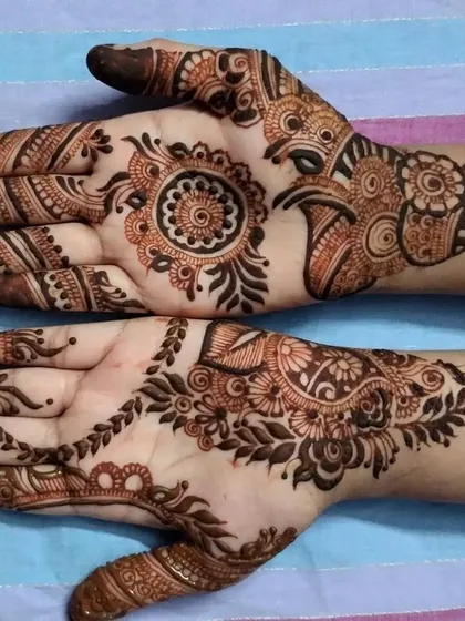 A simple and elegant party henna design from an Eid session. It features a small mandala on one palm and a classic paisley vine on the other.