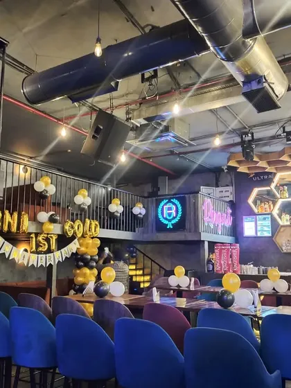 Balloon decorations for a corporate event at a lounge, showing how simple black, white, and gold balloon bunches can enhance a venue.