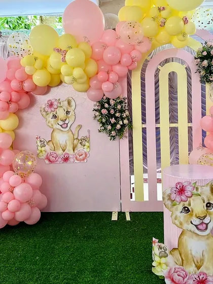 A close-up of the adorable lion cub theme for Dua's second birthday. The soft pink and yellow balloons perfectly complement the sweet, floral lioness character.