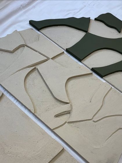 Assembling the puzzle. This shot shows the different sections of the large wall sculpture being laid out before installation.