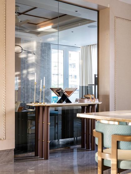 A wider view of the dining and console area, showing how the mirrored wall expands the space and reflects light. The design feels both grand and intimate.
