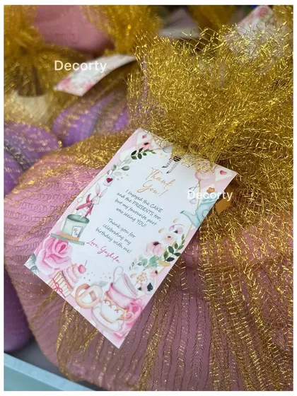 A close-up of the beautifully wrapped return gifts for the Alice in Wonderland party, complete with a custom thank you note.