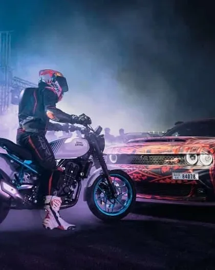 Our performances are a carefully choreographed dance between cars and bikes. This shot captures a moment of synergy between a stunt rider and a drifting muscle car, a highlight of our live event packages.