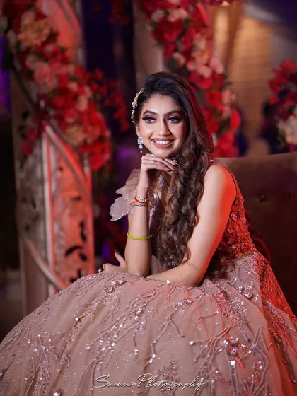 A lovely seated portrait of the bride at her engagement, smiling brightly for the camera.