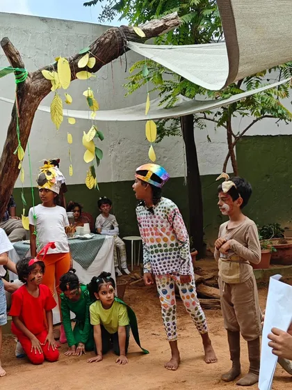 The cast of "The Rainbow Serpent" gathers on our outdoor stage. Putting on a play involves every child, from acting and narration to creating the hand-drawn posters that announce the event.