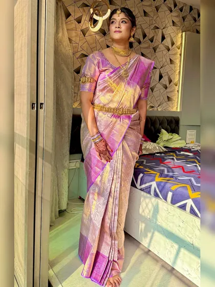 A full-length view of the bride in her beautiful lavender and gold silk saree. The makeup harmonizes with the traditional attire perfectly.