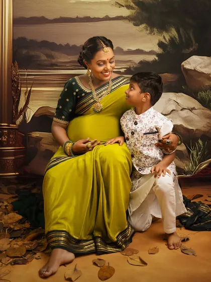 A portrait that feels like a timeless painting. This mother-to-be, dressed in a beautiful traditional saree, shares a quiet moment with her son. I use artistic lighting and painterly backdrops to create these legacy portraits that honor your family's heritage.
