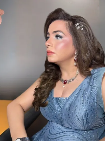 A beautiful party look in a dusty blue gown. The makeup is elegant and refined, with a pop of icy blue on the eyes and a soft, glowing complexion, perfect for an evening affair.