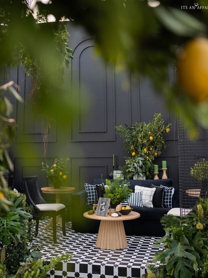 A framed view of a seating area through the lush lemon trees, highlighting the layered and immersive design of the sangeet.