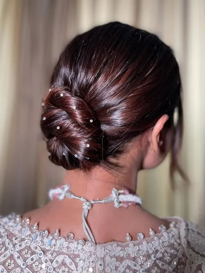 A final look at the sleek Swarovski knot bun, a perfect hairstyle for a modern bride or a chic wedding guest.