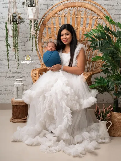 A stunning portrait of a mother and her newborn son. The flowing white dress and boho-chic peacock chair create a beautiful, angelic setting for their first photos together.