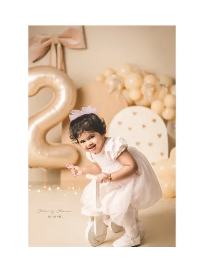 Riding into year two! This little girl is all smiles on her tricycle during her second birthday photoshoot.