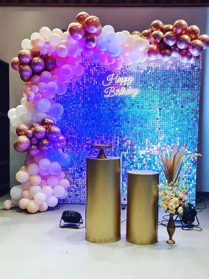 A simple yet glamorous setup perfect for adult birthdays or chic celebrations. This features a shimmering sequin wall that catches the light beautifully, paired with a custom 'Happy Birthday' neon sign and an organic balloon arch.