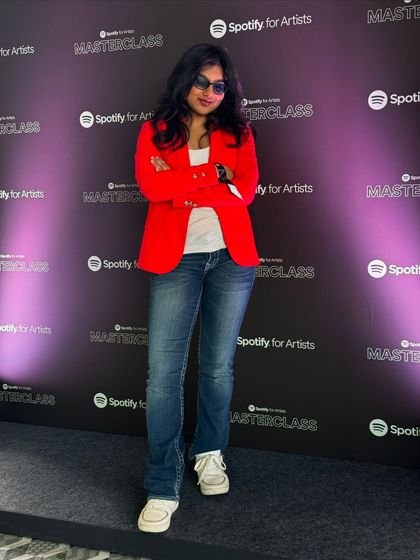 A full-length shot of me at the Spotify Masterclass event. My professional yet cool attire reflects my personality as a modern indie artist.